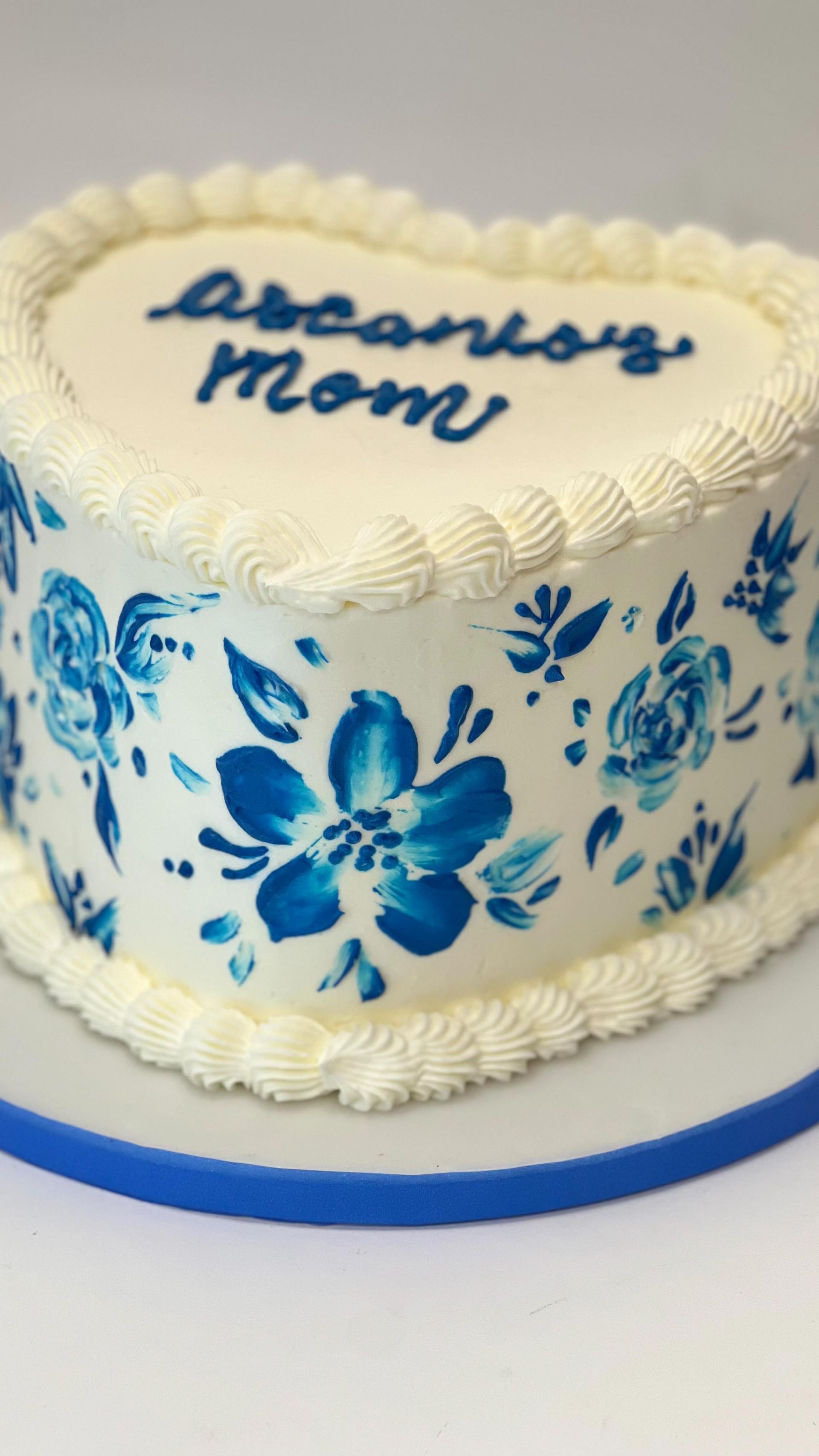 Torta a forma di cuore con motivo floreale blu e scritta