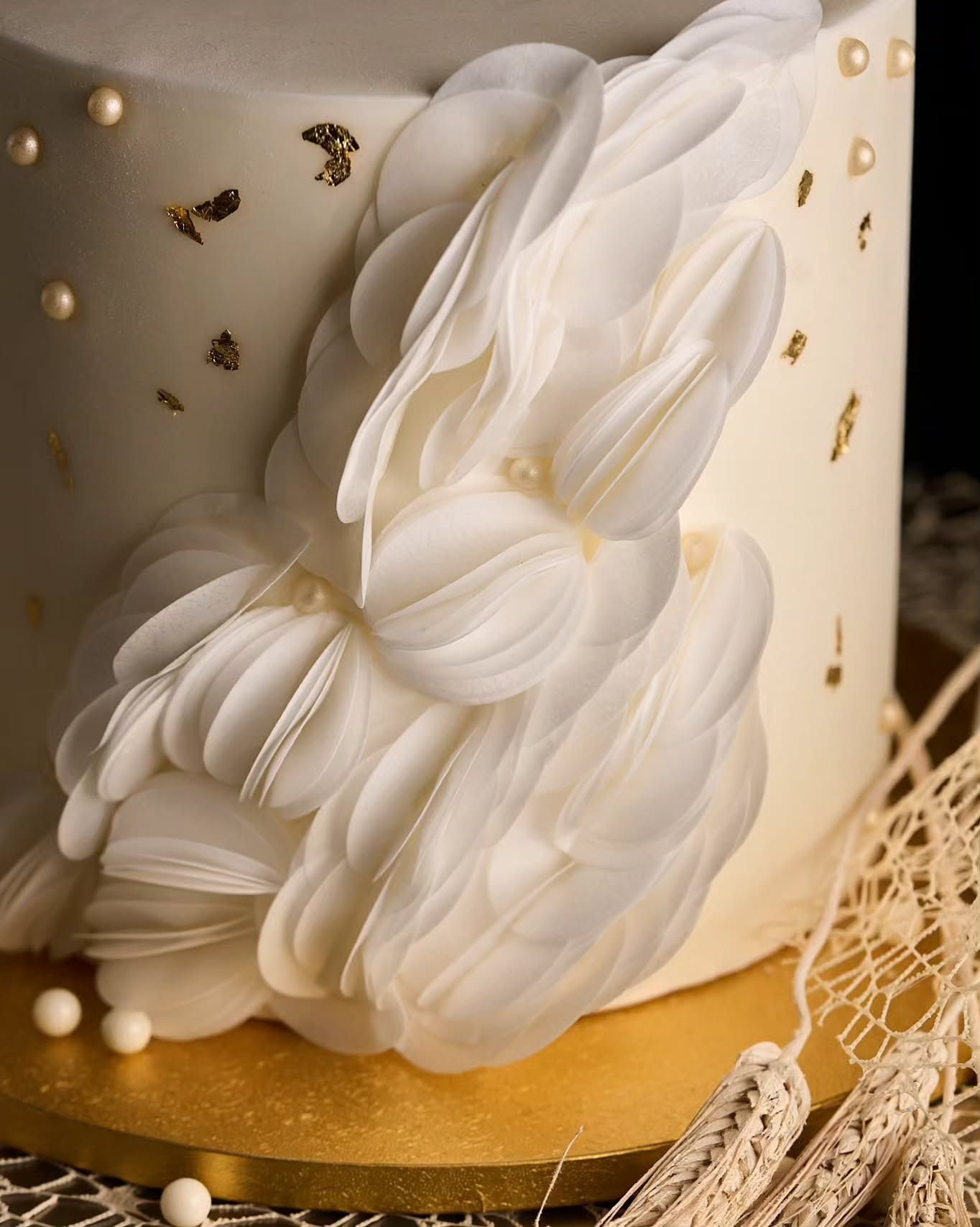 Torta decorata con nastro rosa e bianco, su un'alzata bianca.