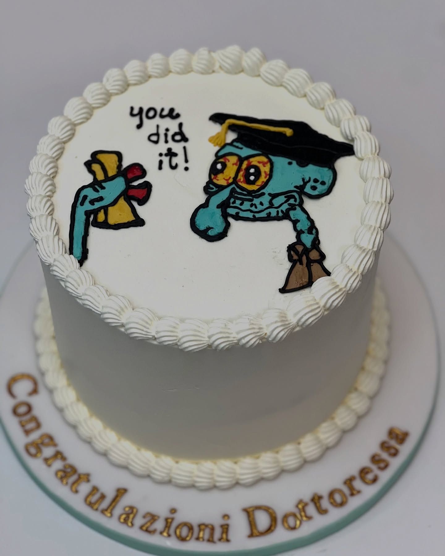 Torta con Squiddi con il cappello da laureato, che tiene in mano un diploma e dice