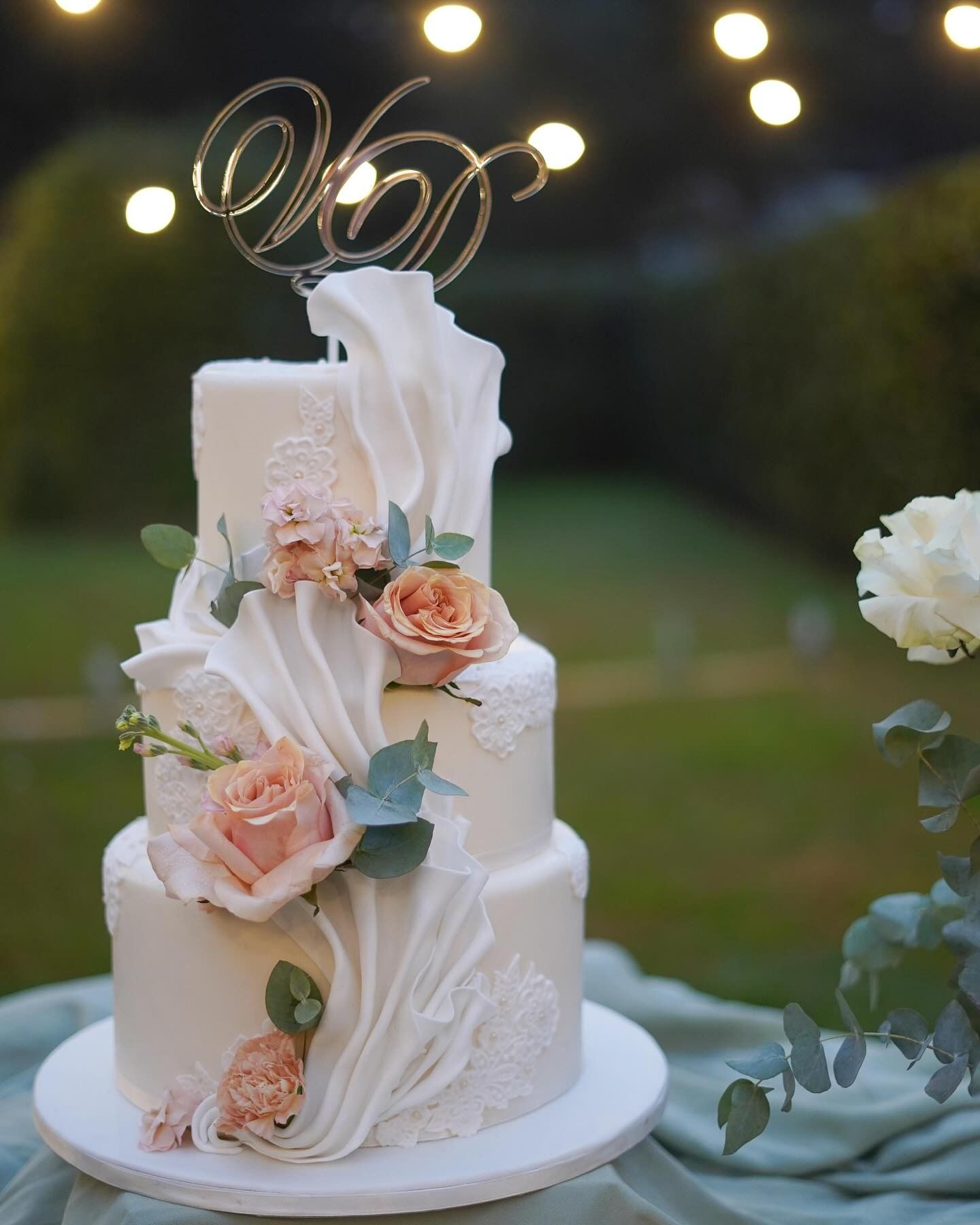 Torta nuziale bianca a tre piani con decorazioni floreali e decorazione 