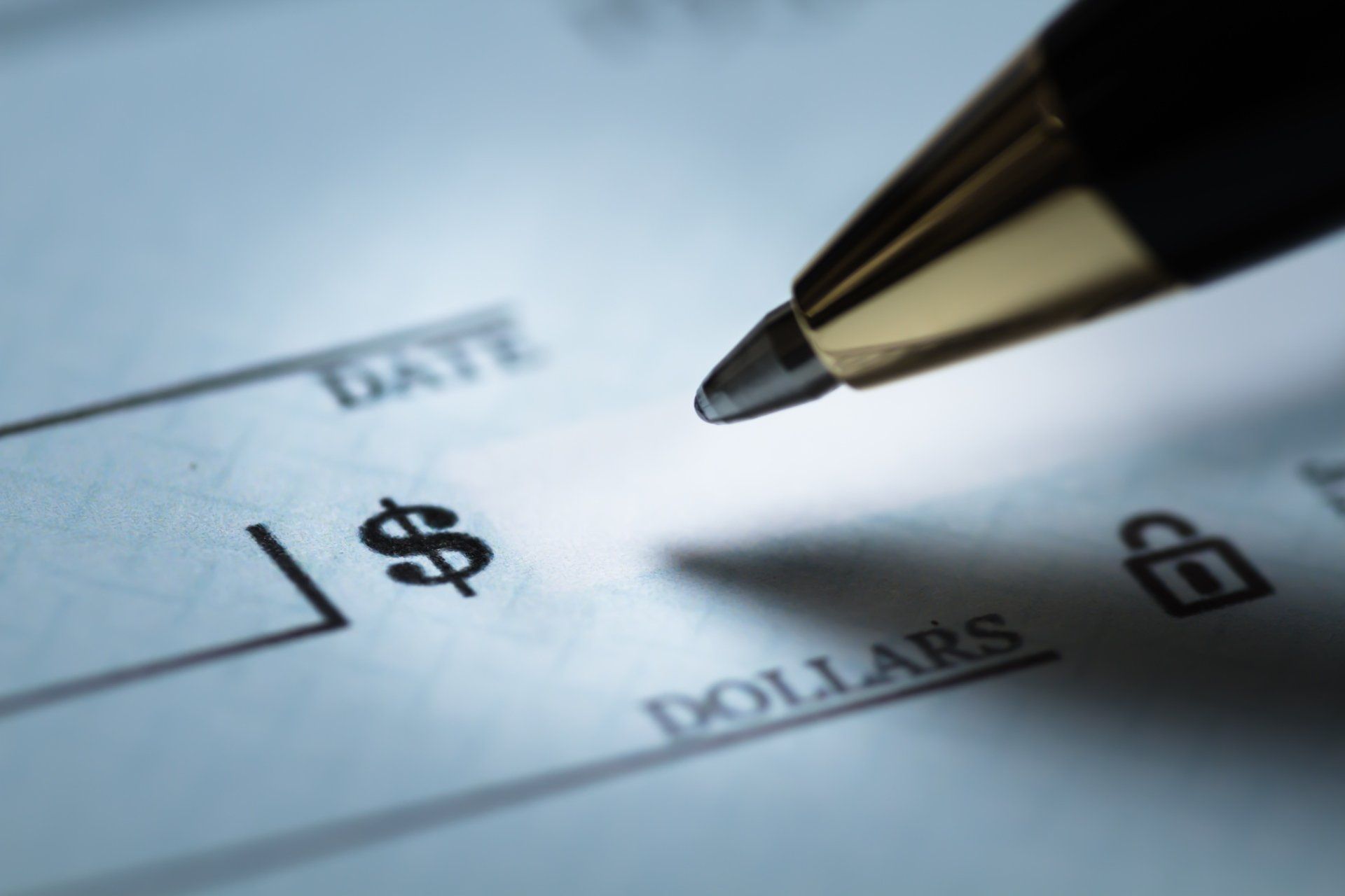A pen is pointing at a dollar sign on a check