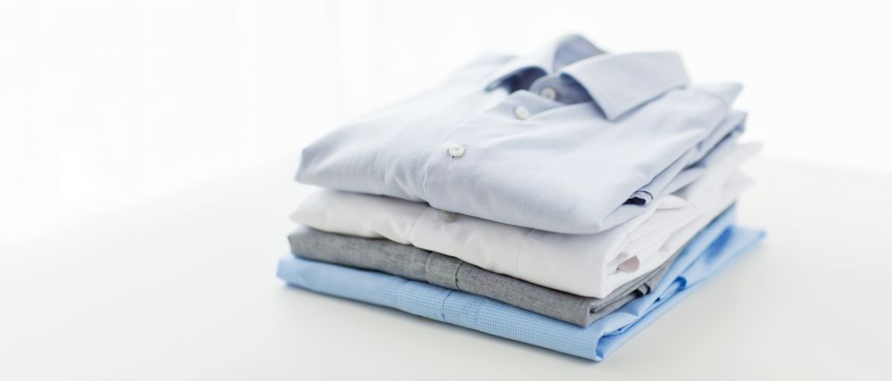 Stack of Folded Dress Shirts in Shades of Light Blue — Flynns Beach Service Laundry in Bonny Hills, NSW
