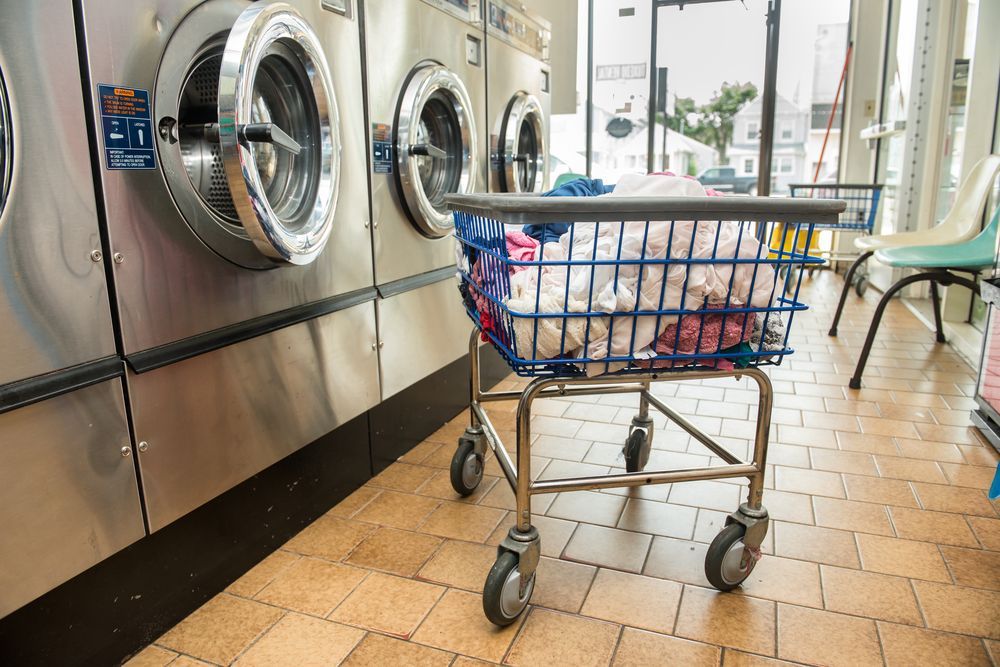 Blue Laundry Cart Filled With Clothes — Flynns Beach Service Laundry in Thrumster, NSW