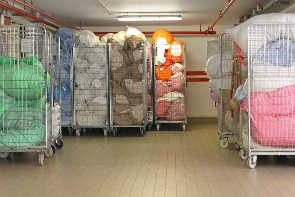 Metal Carts Filled With Bags of Laundry — Flynns Beach Service Laundry in Lighthouse Beach, NSW