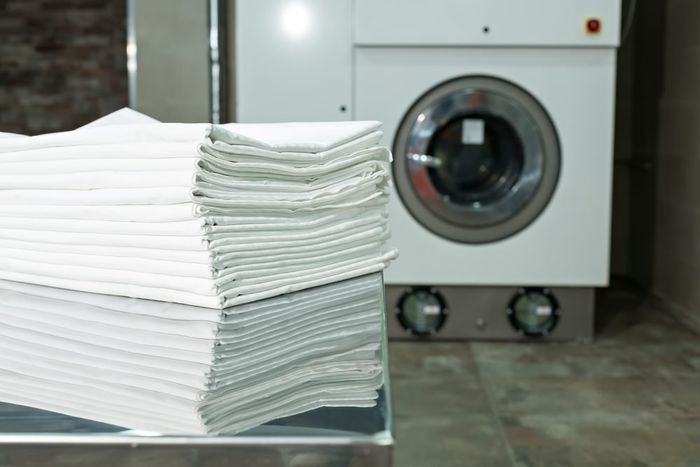 Neat Stack of Folded White Linens — Flynns Beach Service Laundry in Port Macquarie, NSW