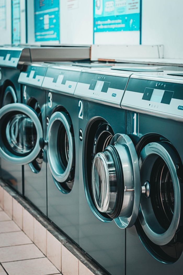 Row of Green Industrial Washing Machines — Flynns Beach Service Laundry in Port Macquarie, NSW