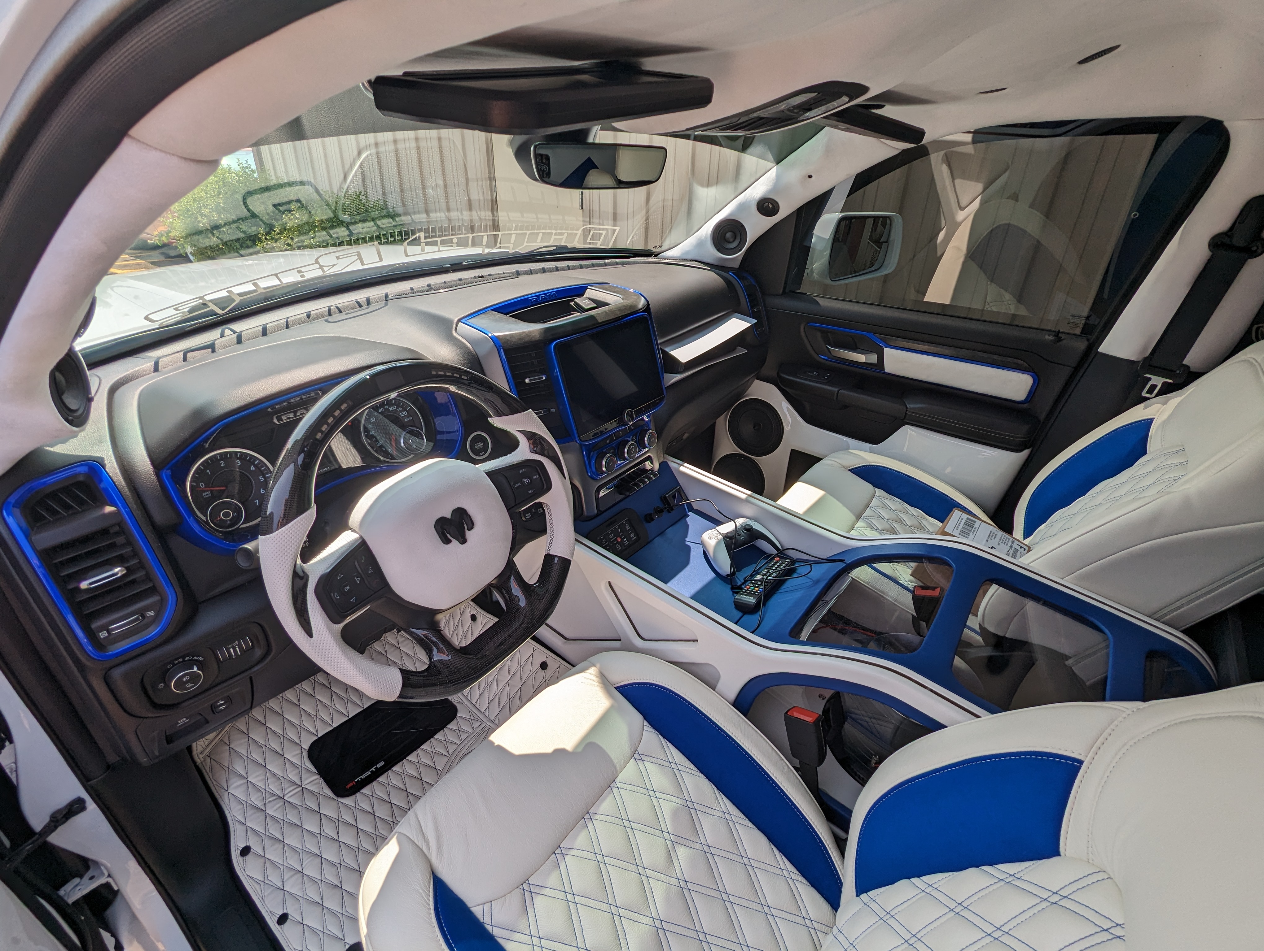Customized white and blue truck interior with leather seats, dashboard, and steering wheel.