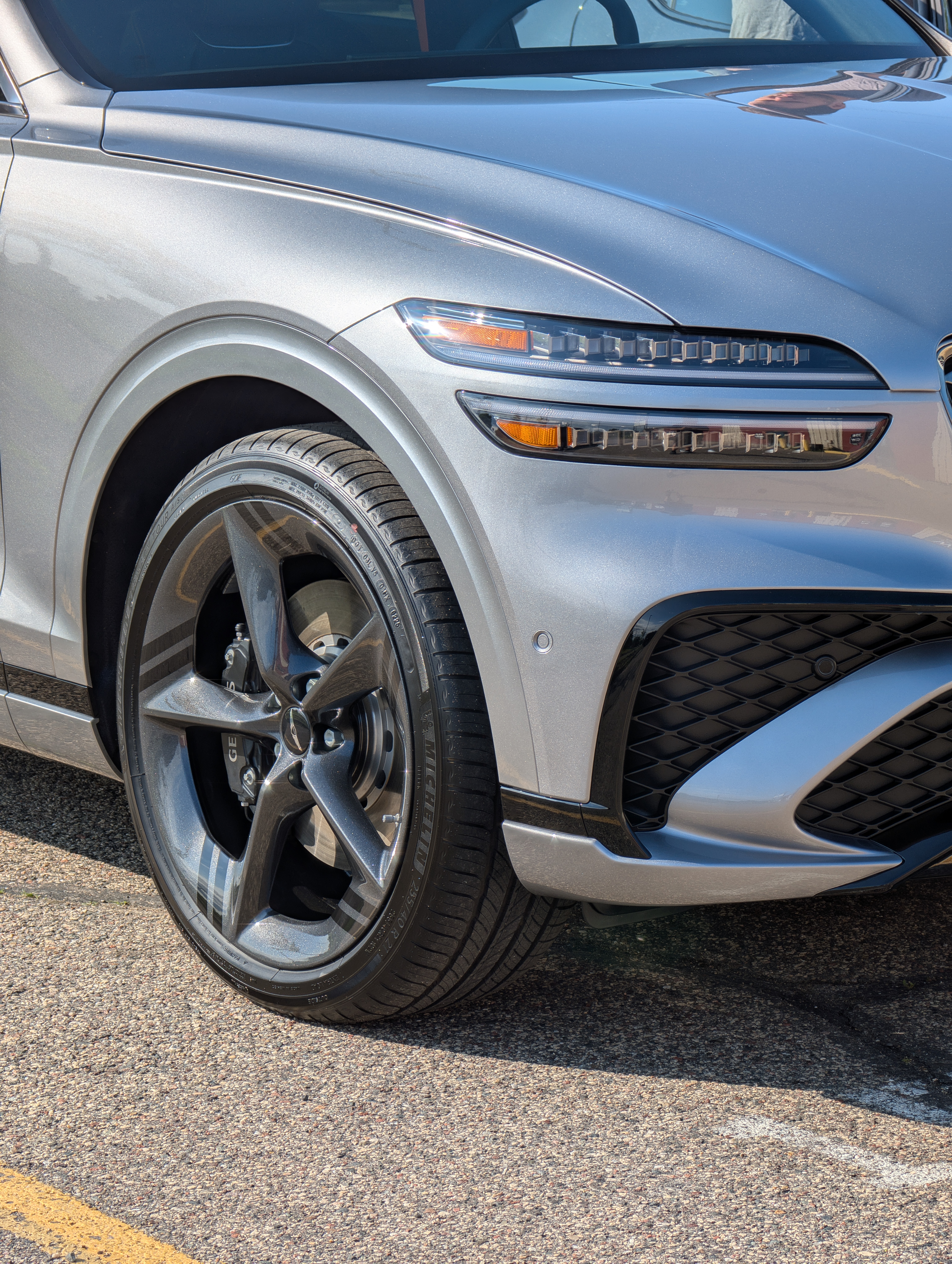 Person wearing a black glove applying a blue ceramic coating to a black car.