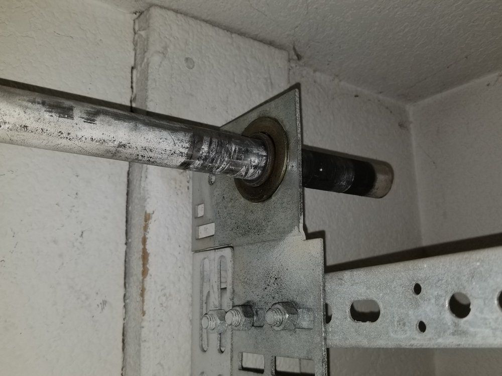 Rusty metal pipe passing through a bracketed wall opening in an industrial interior
