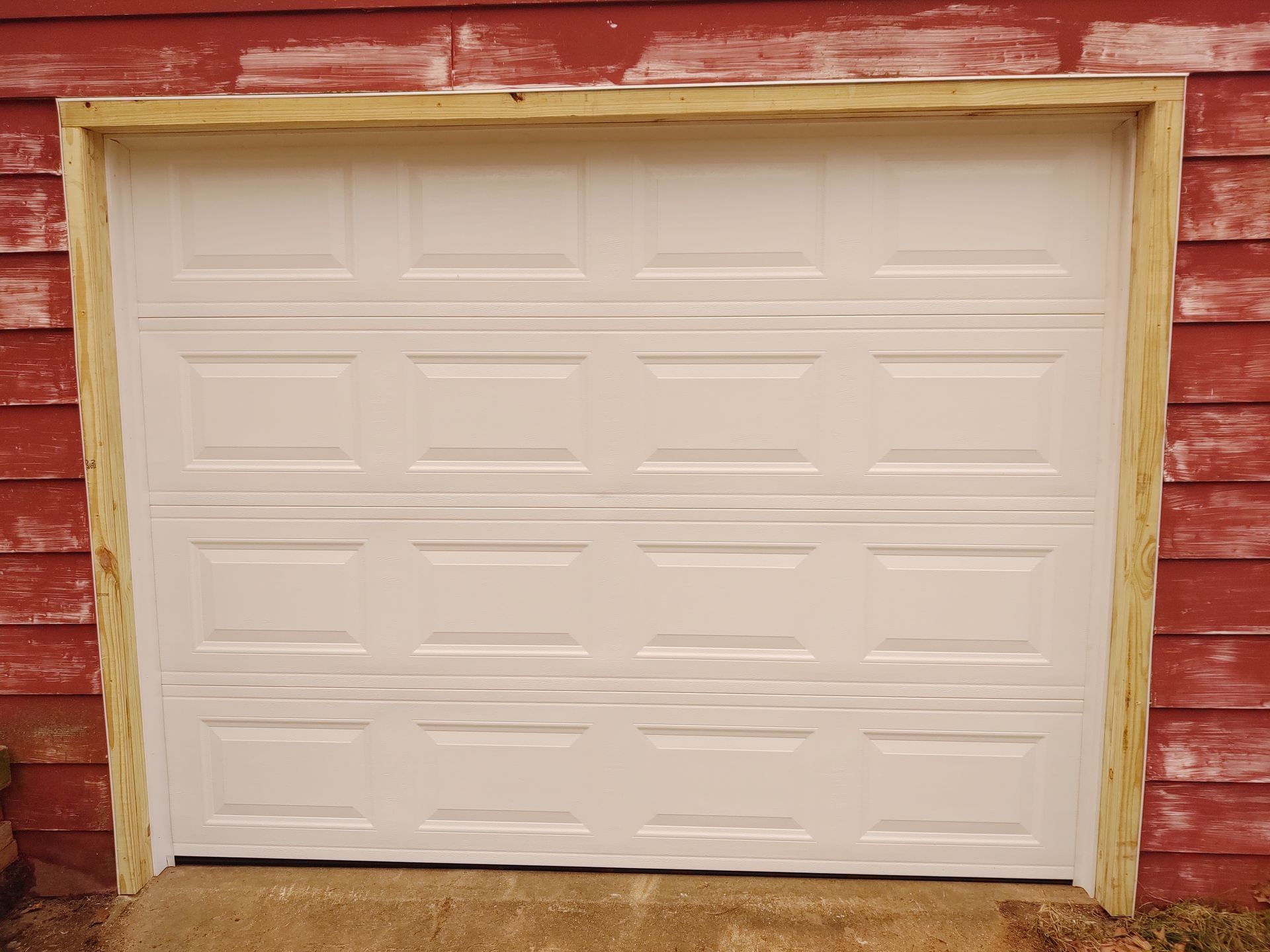 White garage door in a red wooden wall with yellow trim