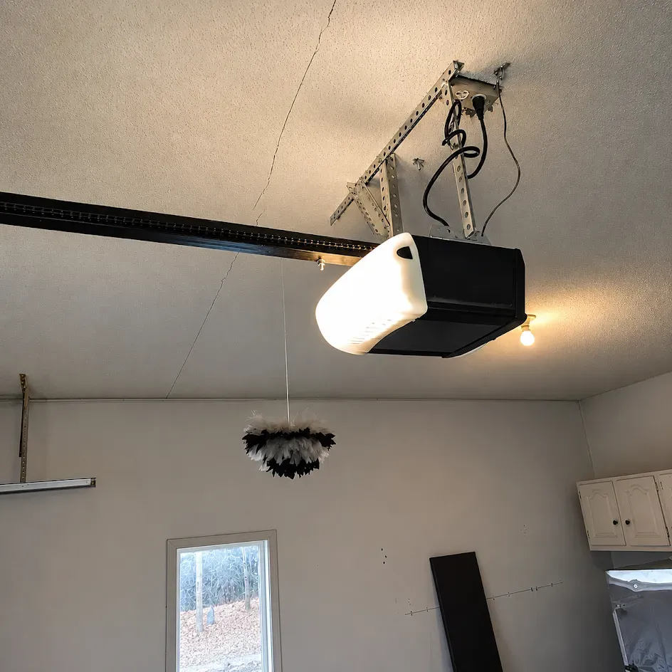 Exposed silver ductwork and pipes in an unfinished room with wood beams and an open doorway