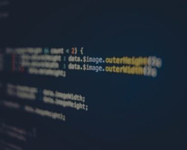 Lines of computer code, in white and red, on a dark blue screen.