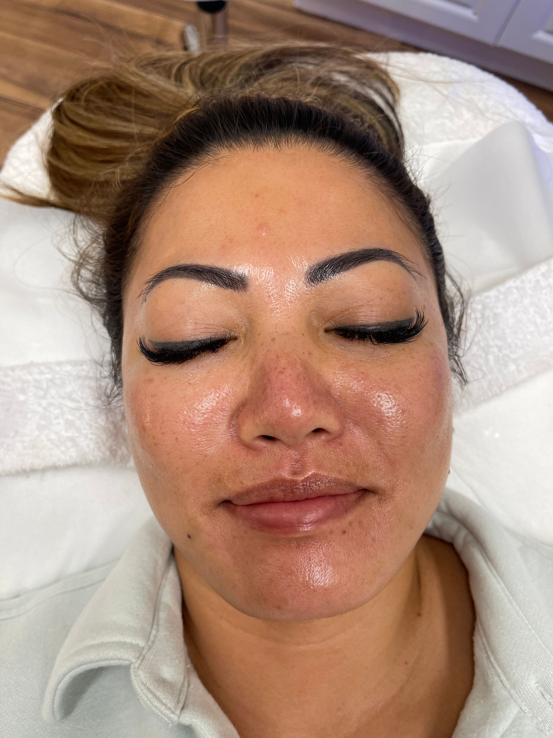 A woman is laying on a table with her eyes closed.