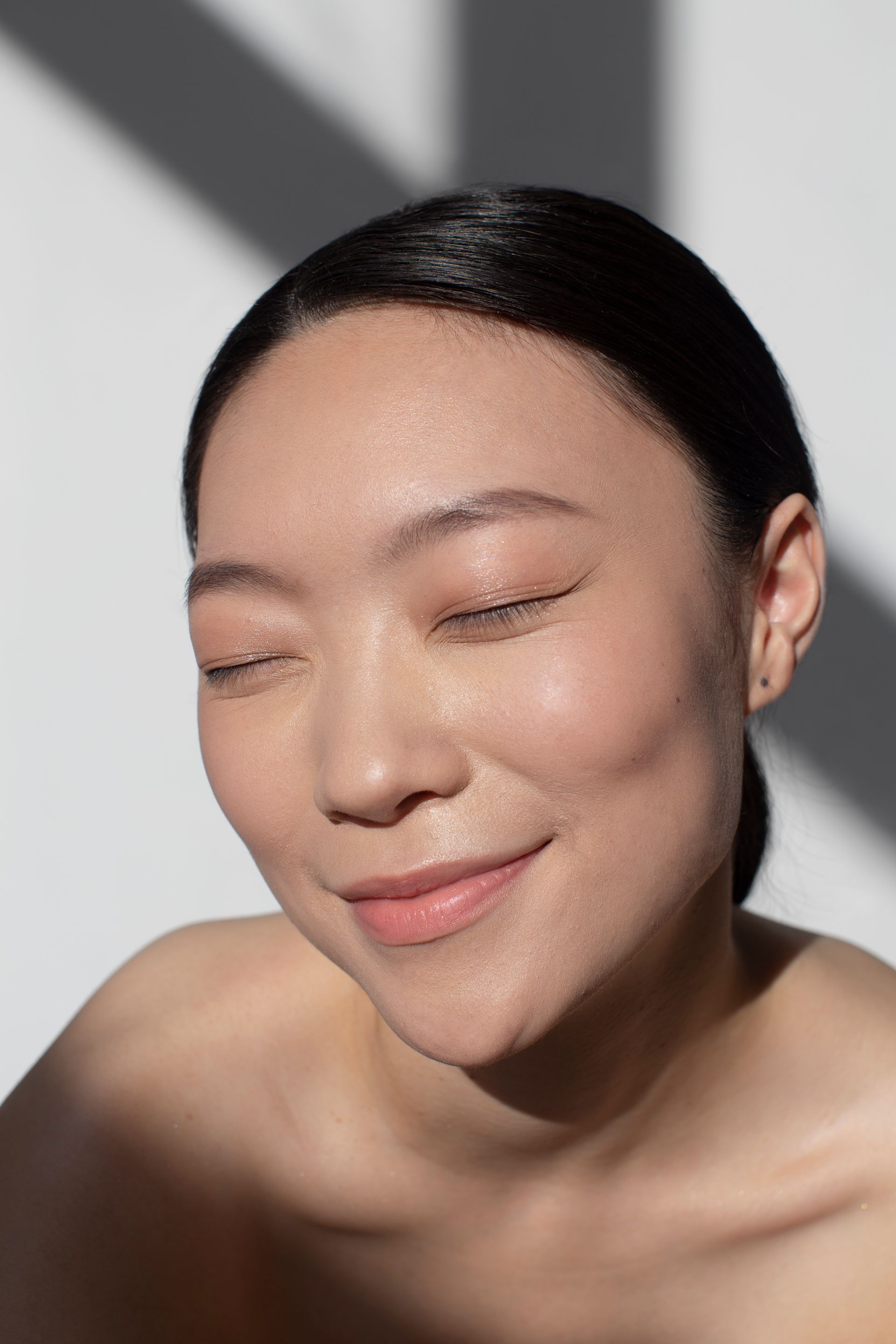 A close up of a woman 's face with her eyes closed.