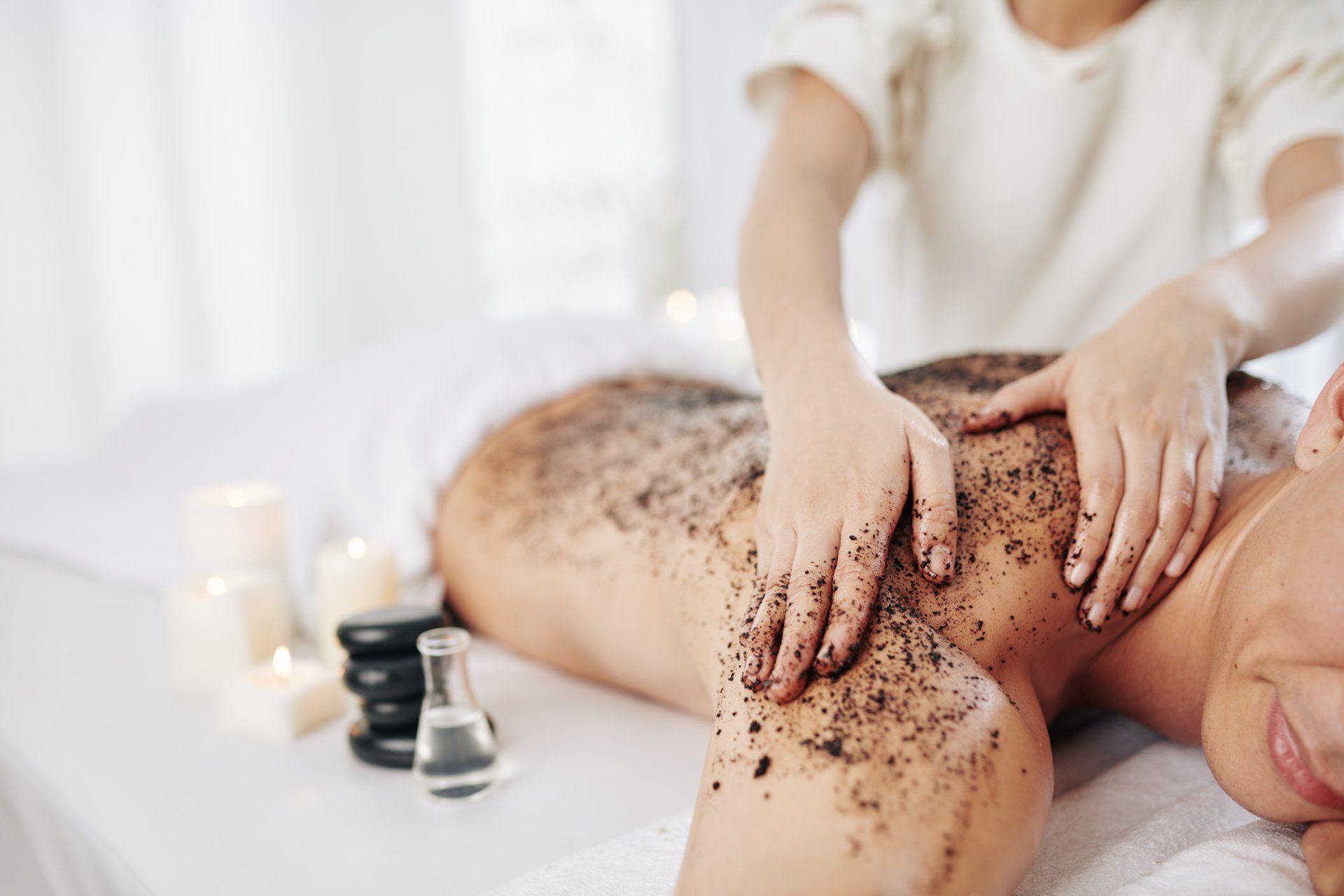 A woman is getting a body scrub at a spa.