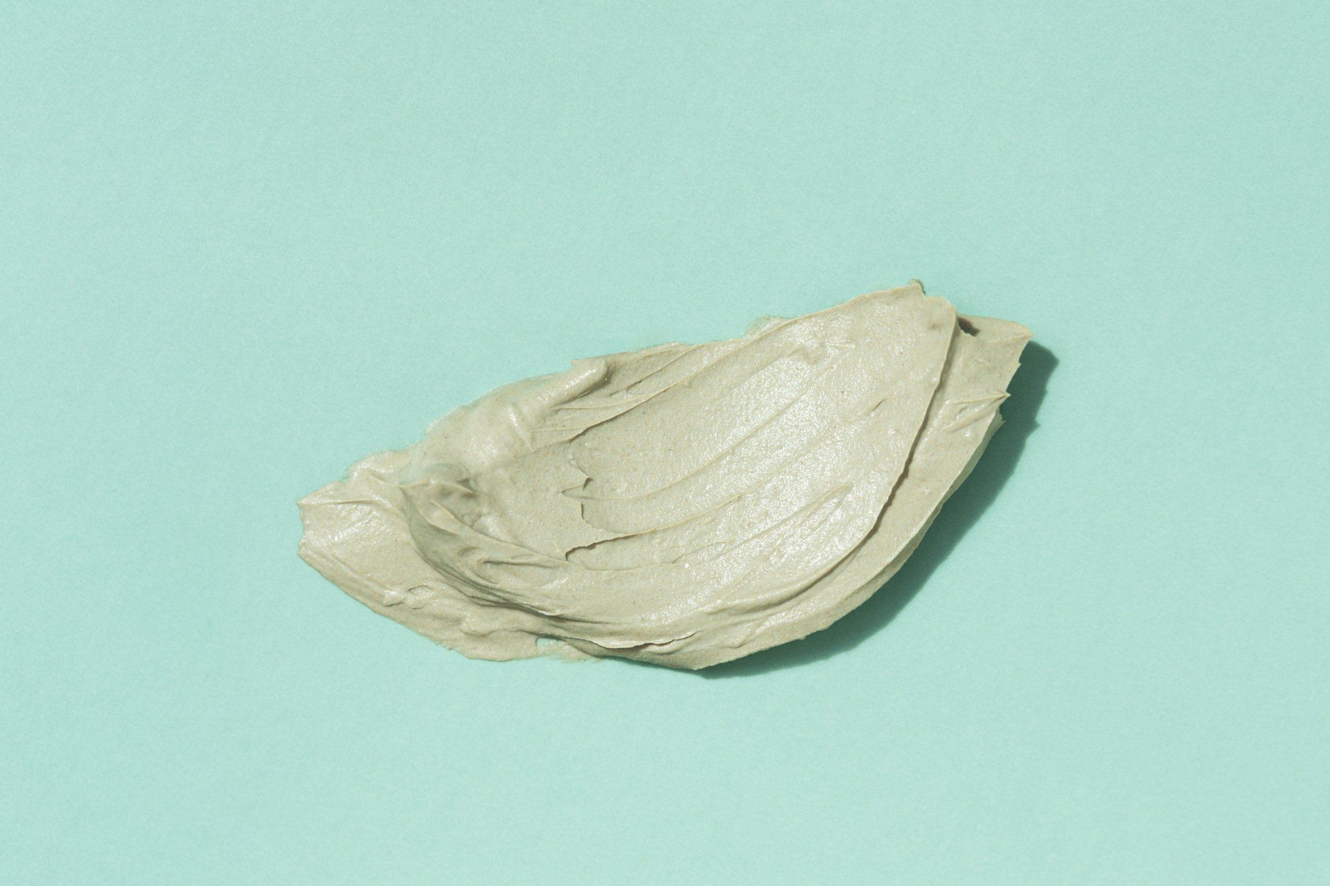 A swatch of green clay on a blue surface.