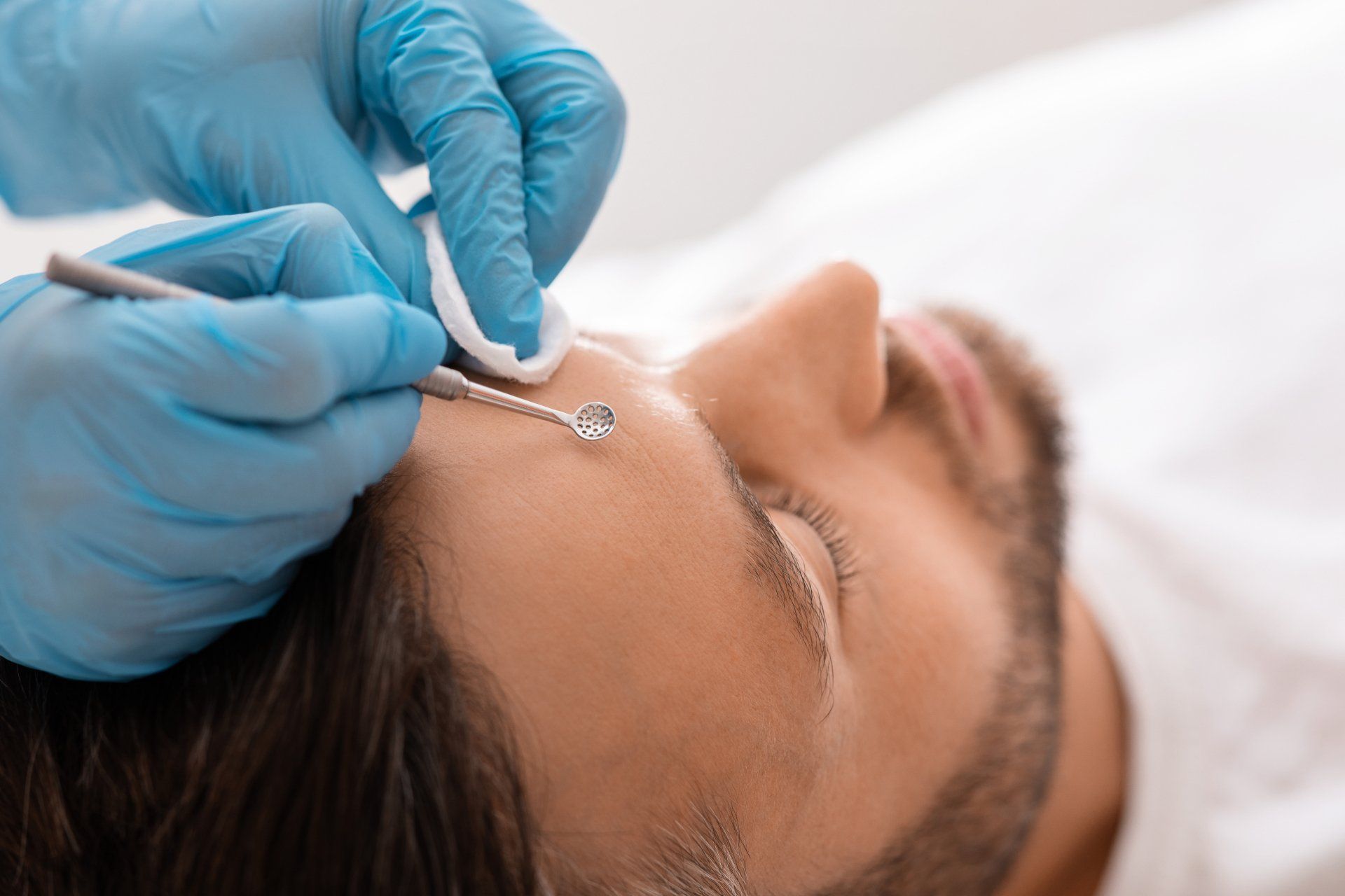 A man is getting a facial treatment at a beauty salon.
