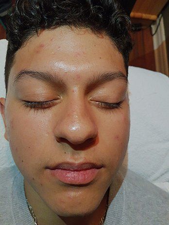 A close up of a young man 's face with his eyes closed.