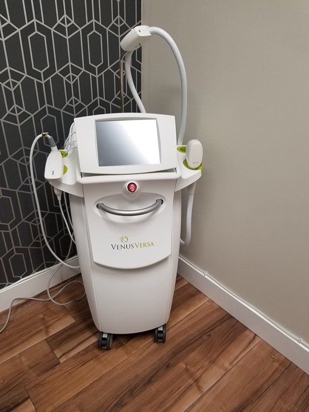A white machine is sitting on a wooden floor in a room.