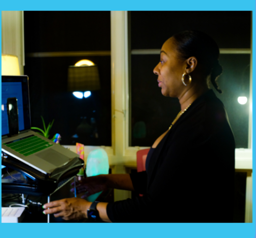 Woman at computer in front of window, working late at night.