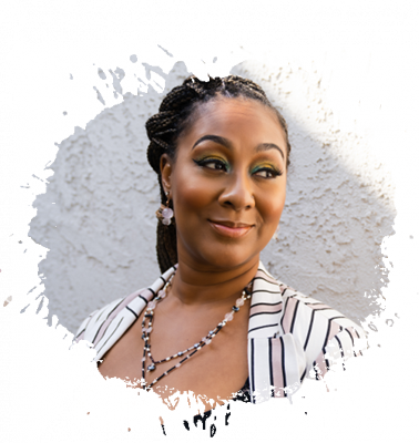 Woman with braided hair, wearing a striped jacket and beaded necklaces, smiling. Light background with paint splatter effect.