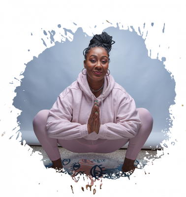 Woman in pink outfit in a yoga pose with hands together; on a mat.