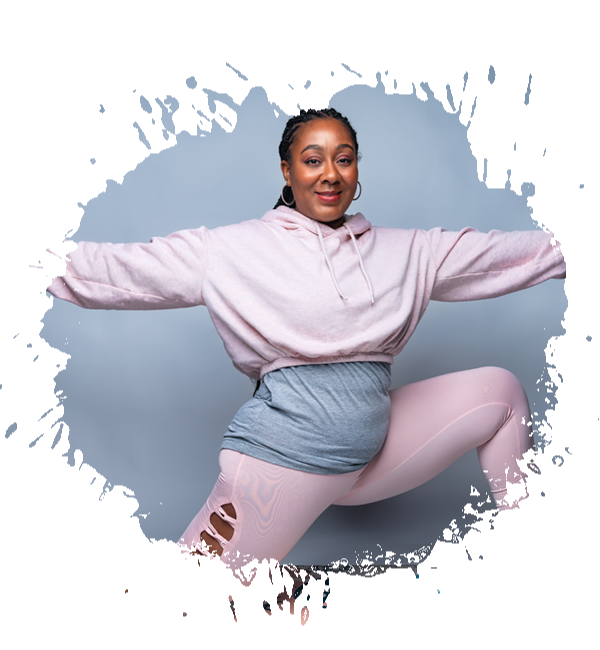 Woman in pink athletic wear poses with arms outstretched.