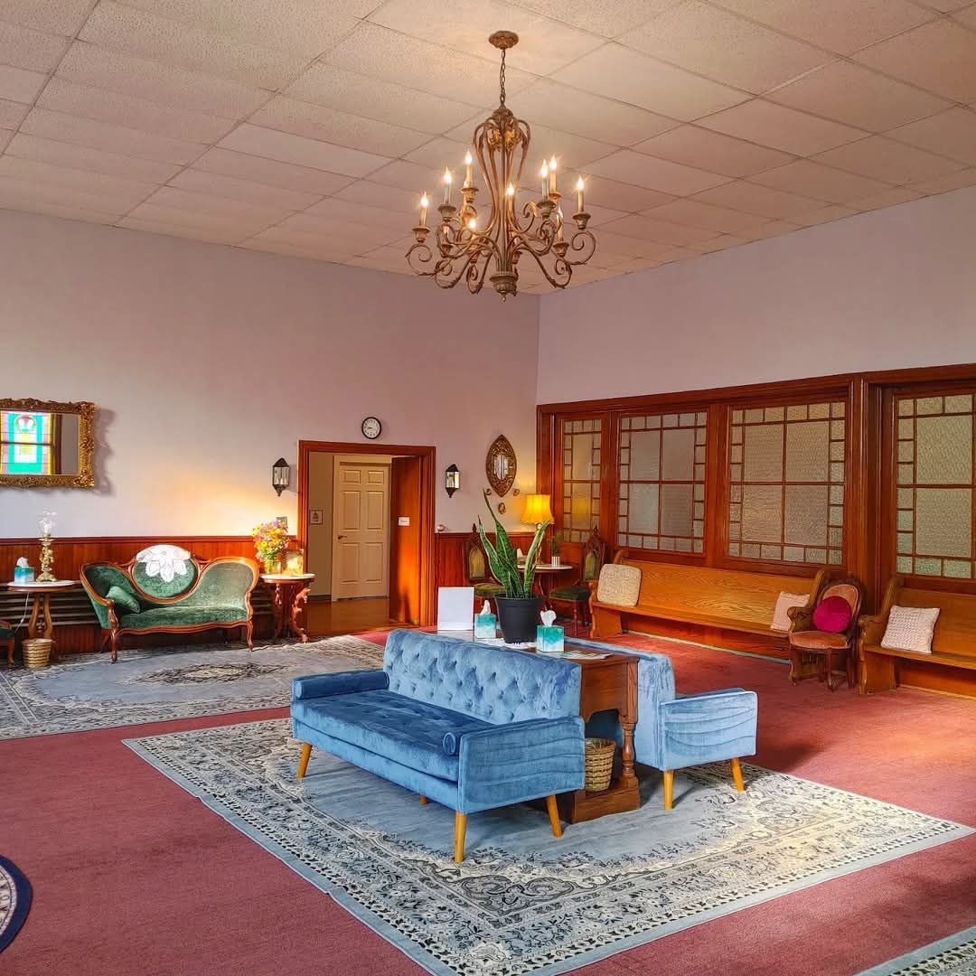 A living room with a blue couch and a chandelier