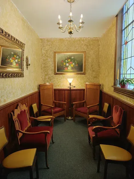 A room with chairs and a painting on the wall
