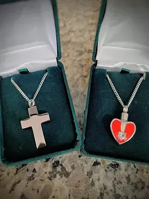Two necklaces , a cross and a heart , are in green boxes.