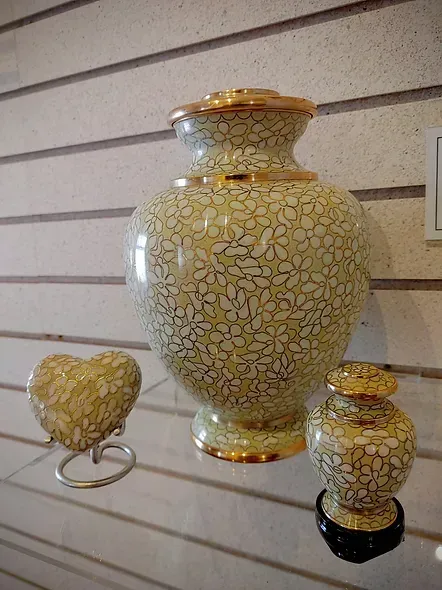 A vase and a heart are sitting on a shelf.