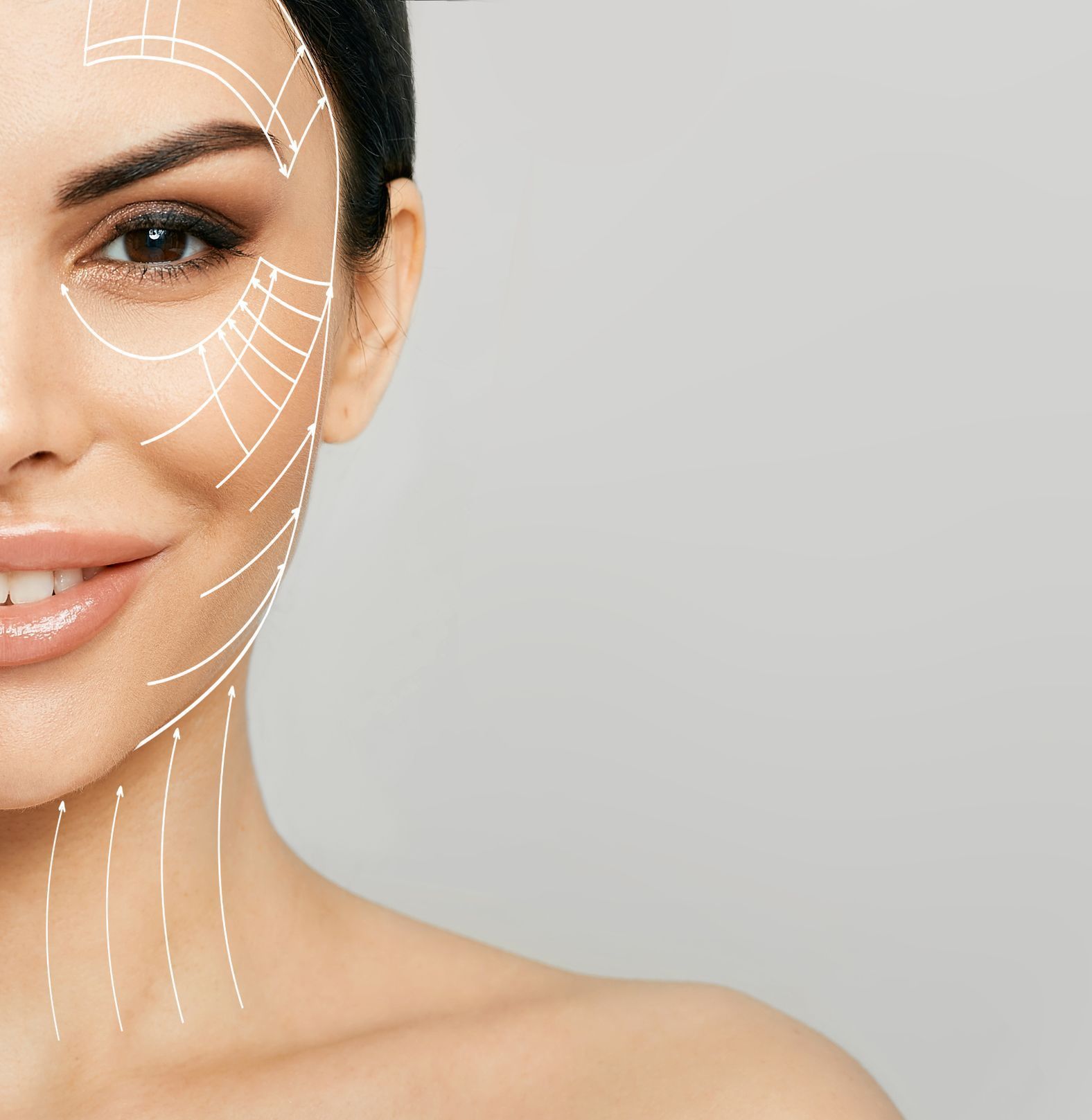 closeup of mature female model with dark hair and directional arrow lines on face, for facelift concept