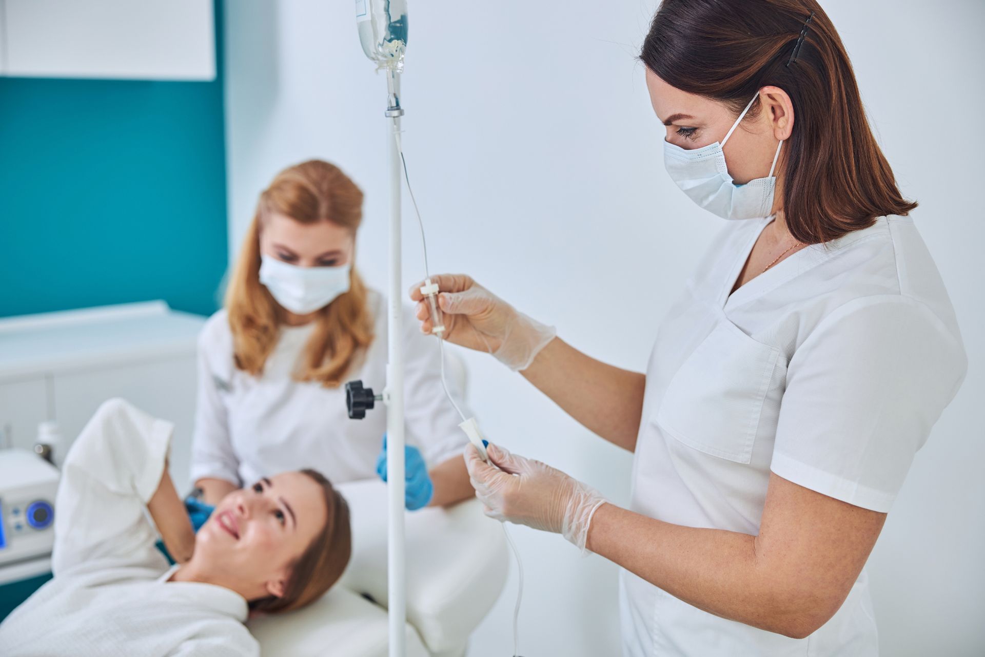 medical staff prepares IV hydration infusion for young female patient
