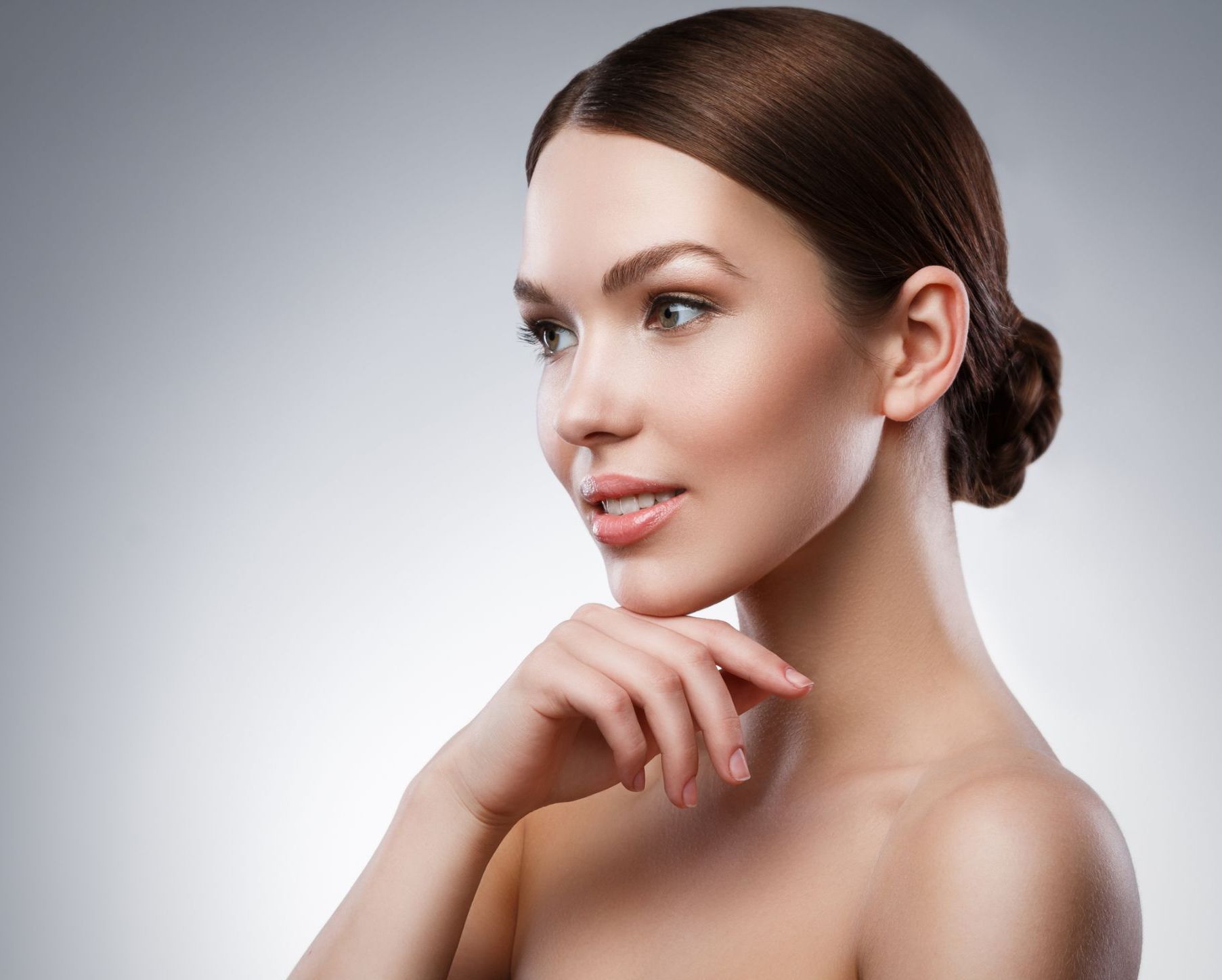 beautiful dark haired female skincare model with hand under chin