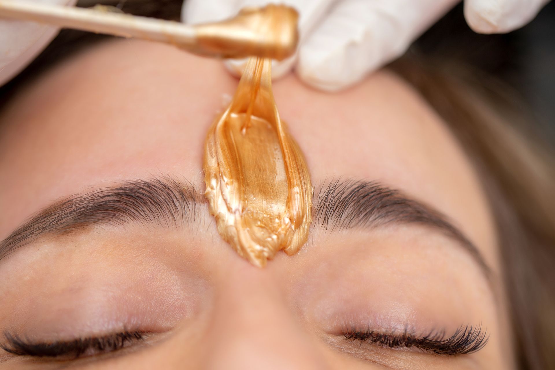 Applying Facial Wax Between Eyebrows – Terrigal, NSW - Anjule Beauty Therapy