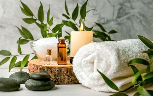 A Woman With A Towel Wrapped Around Her Head Is Using A Jade Roller On Her Face – Terrigal, NSW - Anjule Beauty Therapy