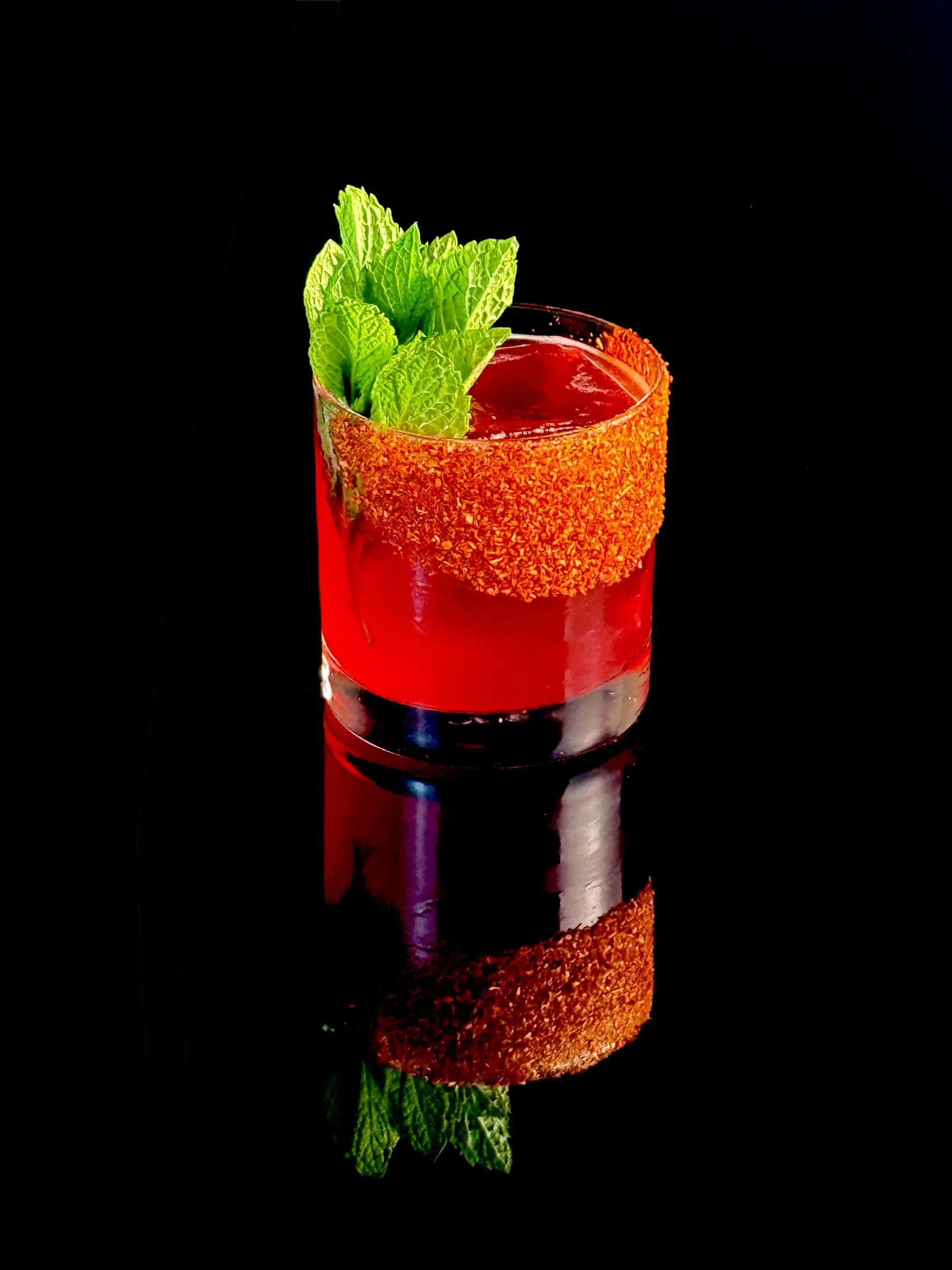 Sippin’ Pretty, hibiscus-infused tequila, orange bitters, mint, and Tajín in a vivid rocks-glass serve