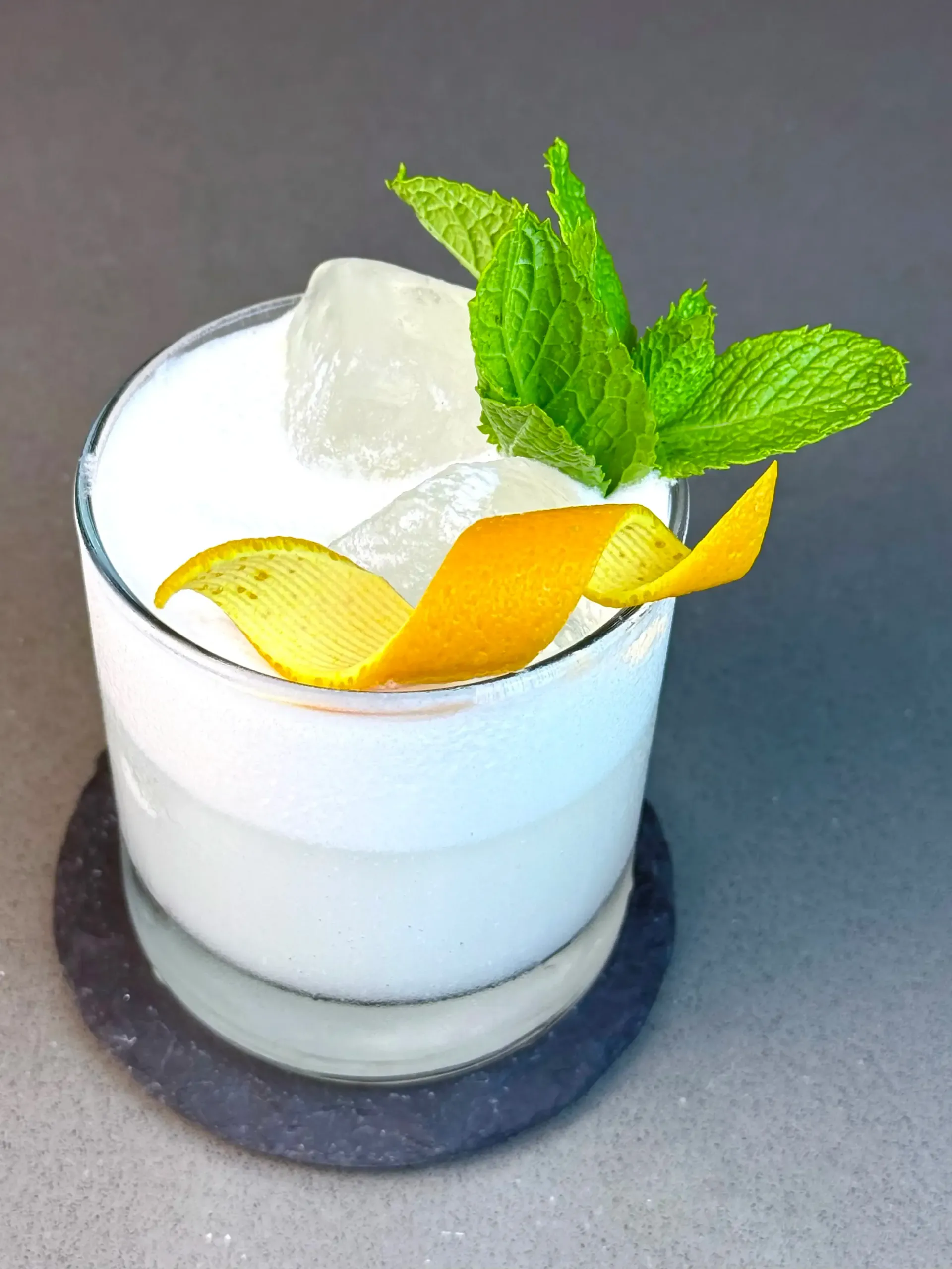 Tangy Tides, a creamy-tart tequila sour combining tamarind, coconut milk, mint, and orange zest