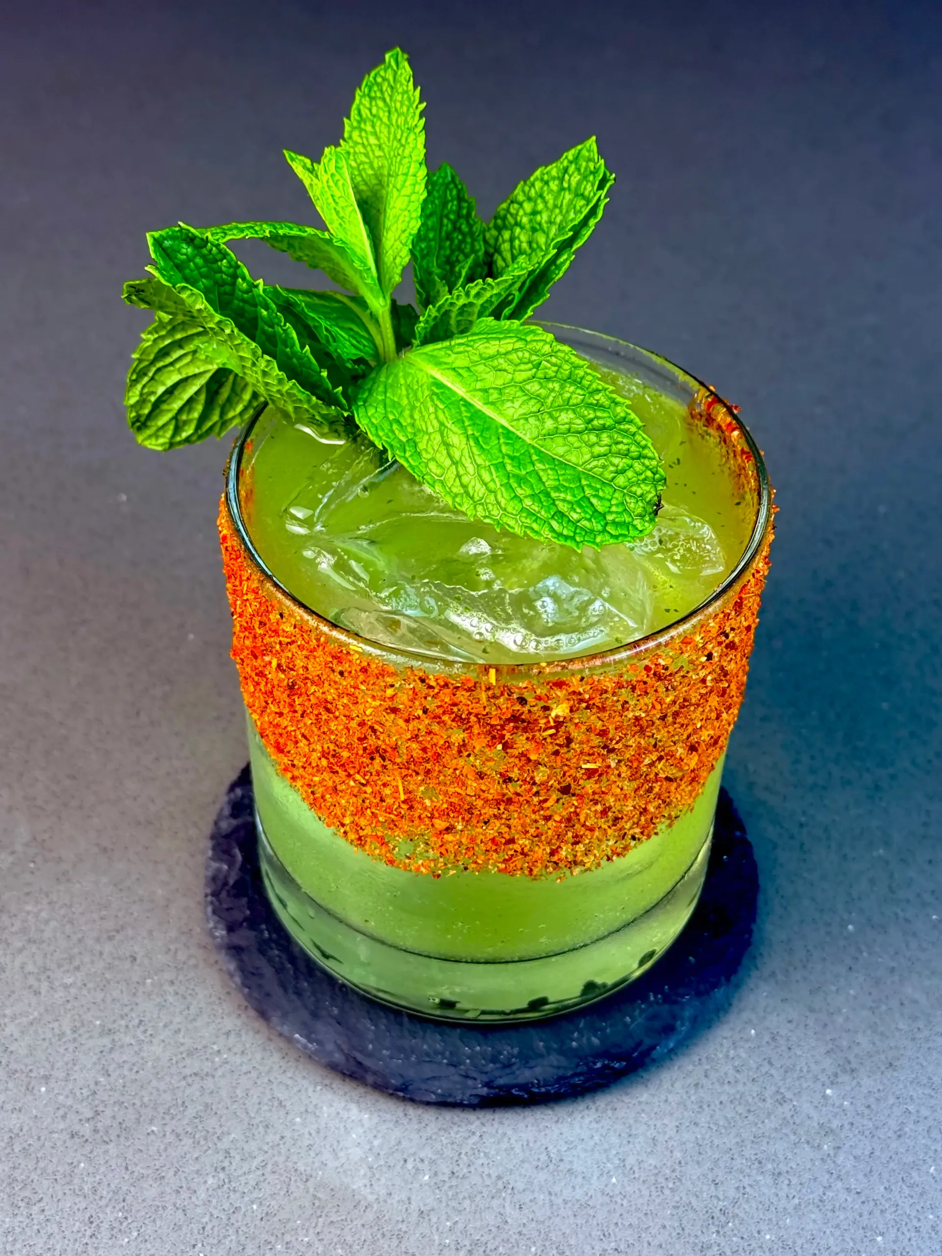 Tamarindo Verde cocktail with tequila, tamarind, mint, and Tajín rim