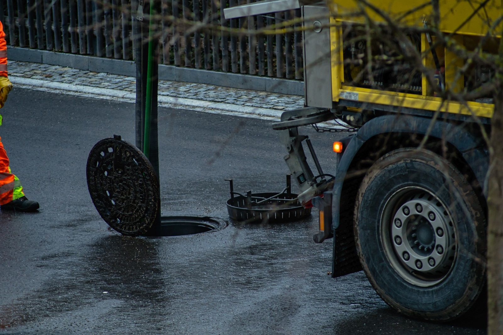 Un camion sta rimuovendo il coperchio di un tombino.