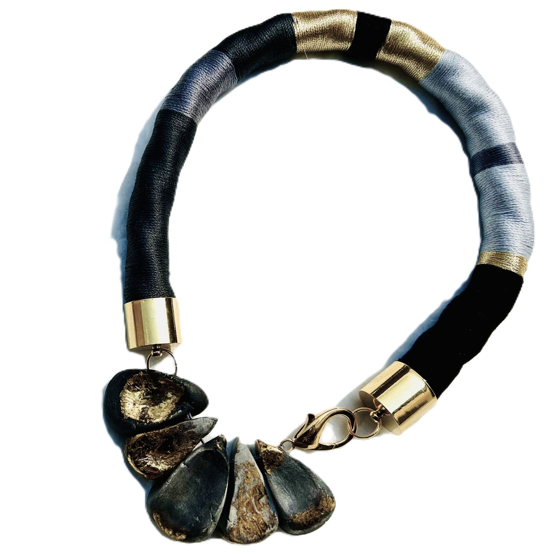 Un collar negro y dorado con un cierre dorado.