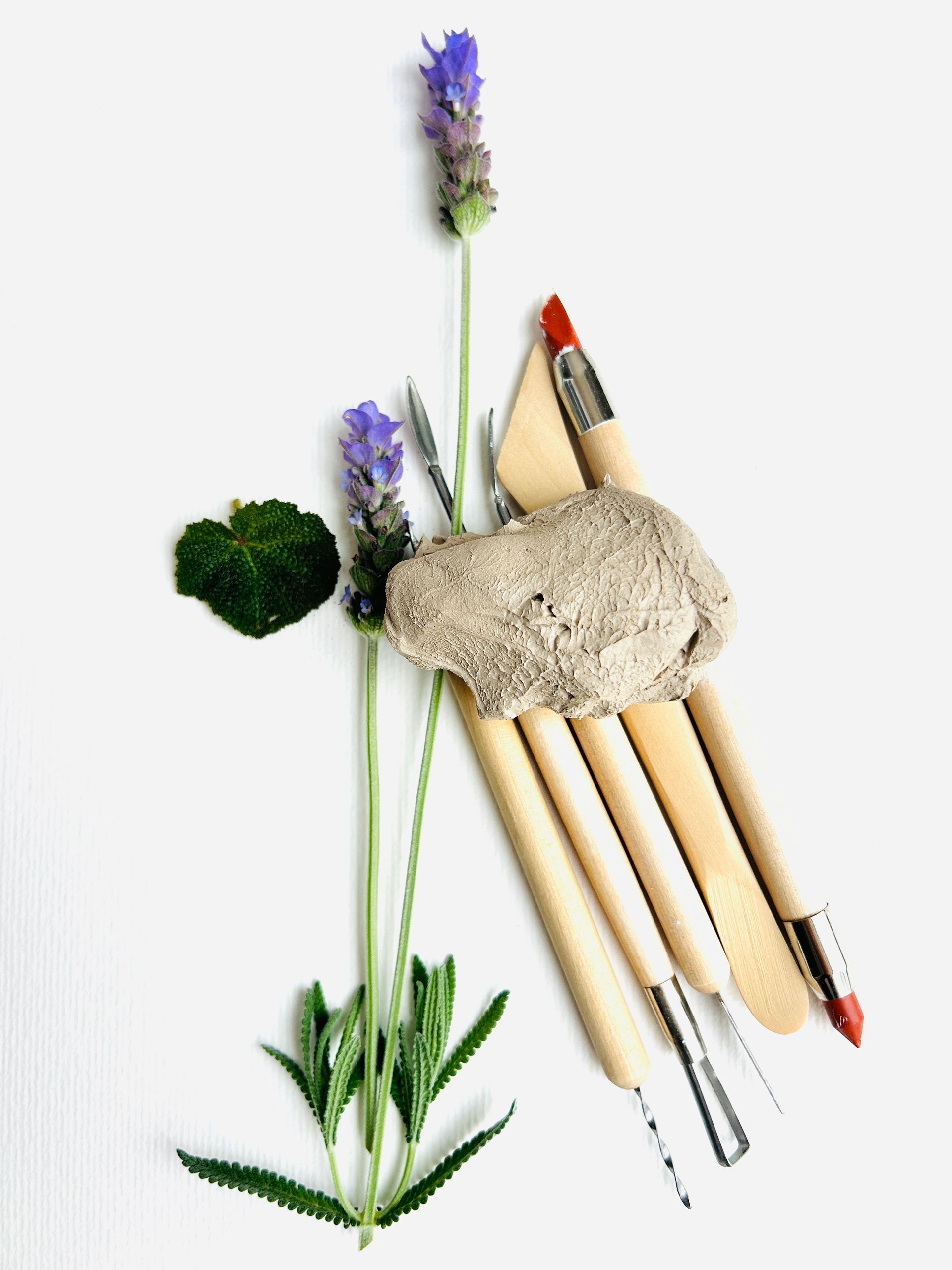 Un ramo de pinceles y flores sobre una superficie blanca.