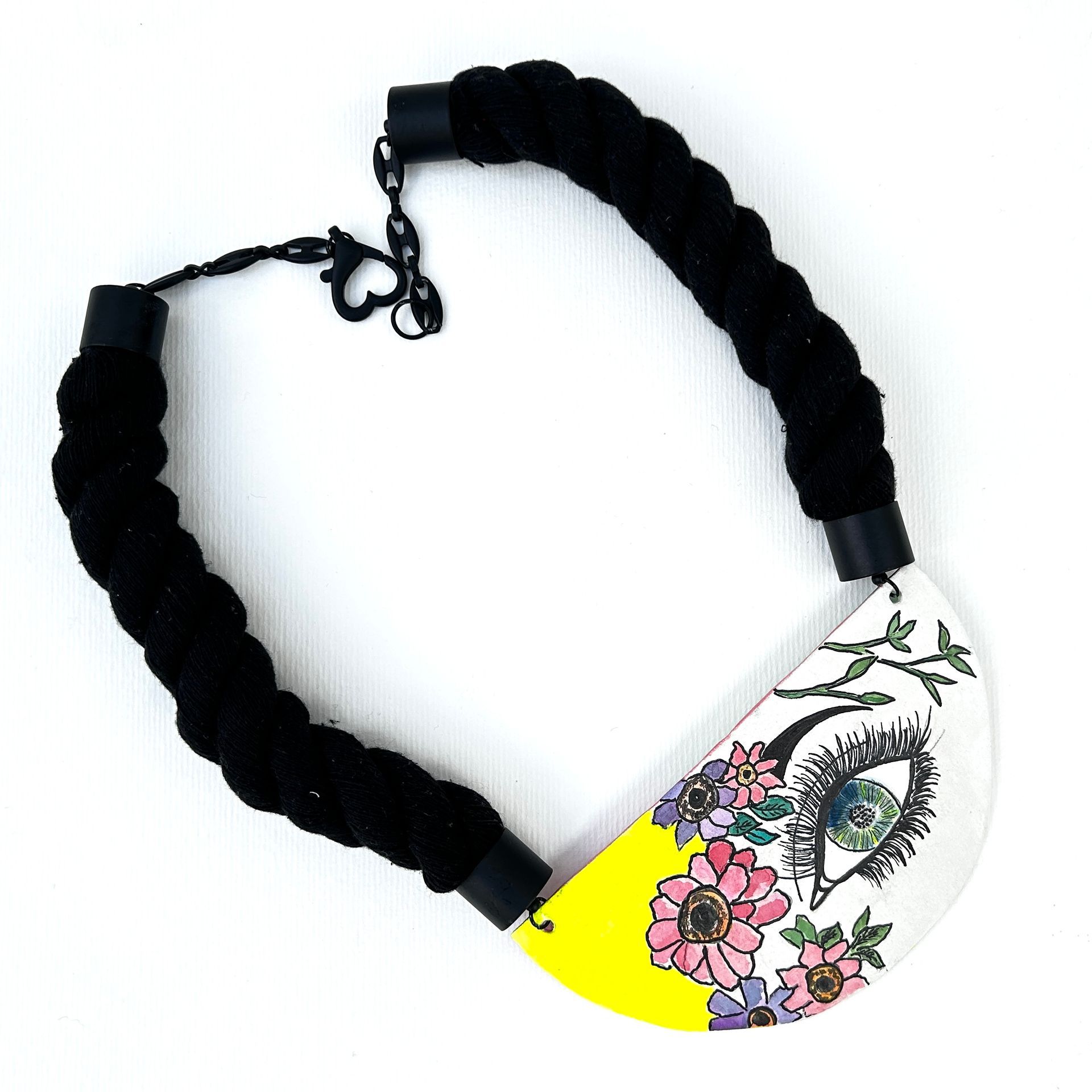 Un collar con un colgante amarillo con flores.
