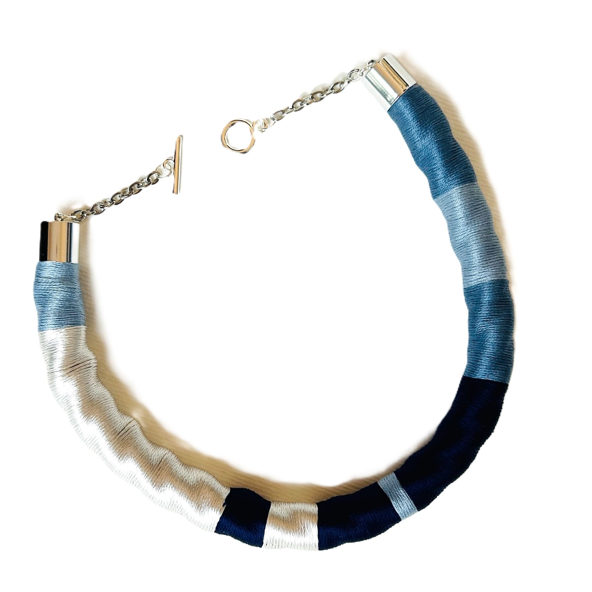 Un collar azul y blanco con una cadena de plata.