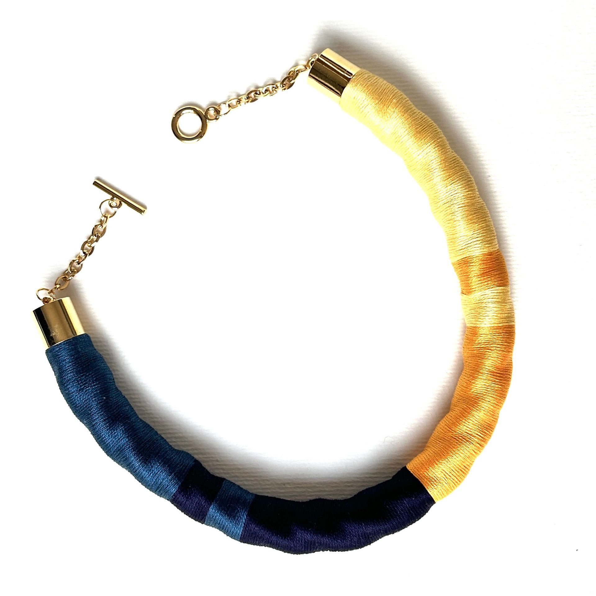 Un collar azul y dorado con un cierre dorado.