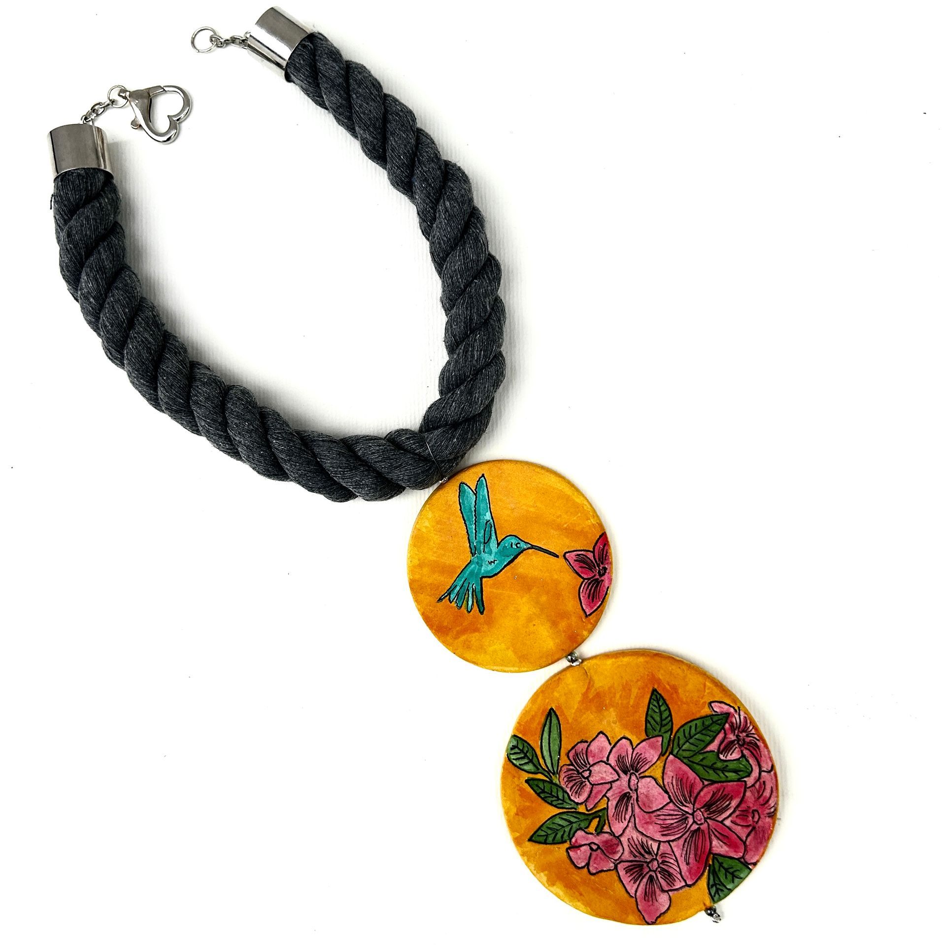 Un collar con un colibrí y flores.