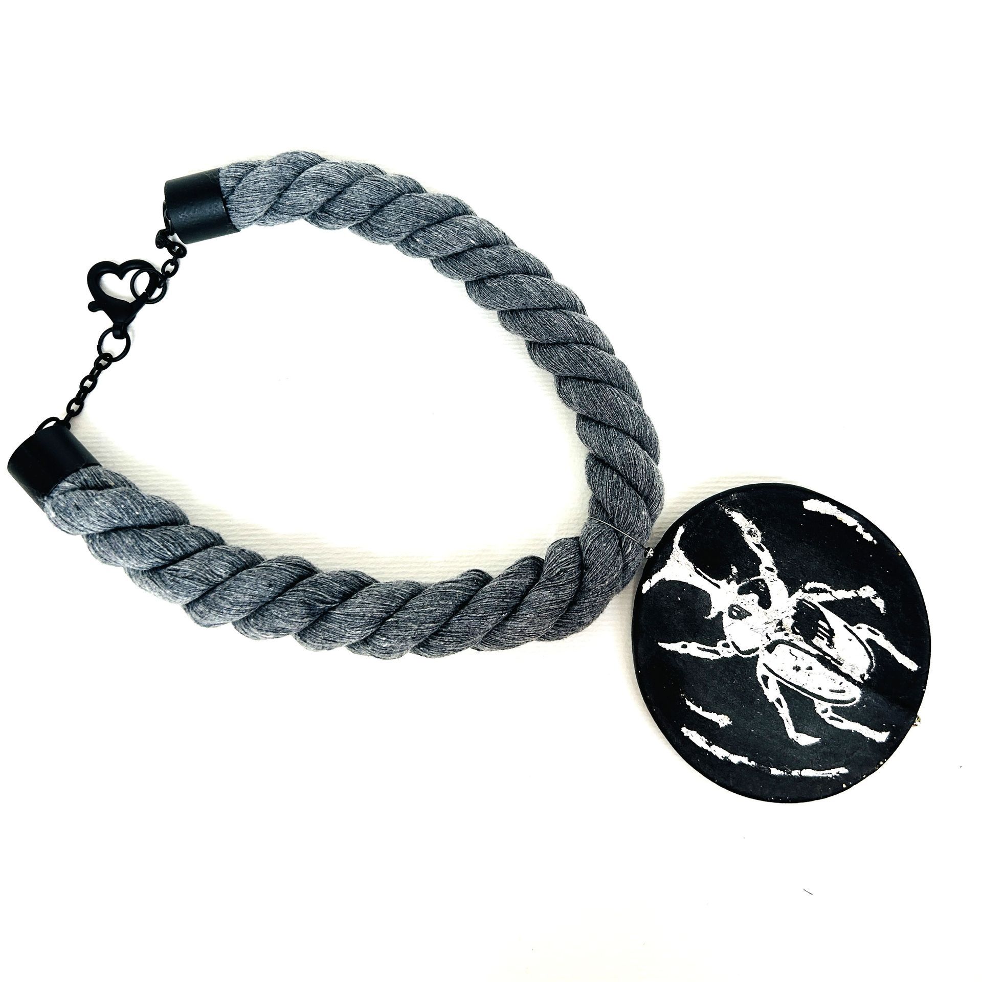 Un collar de cuerda con un colgante de araña.