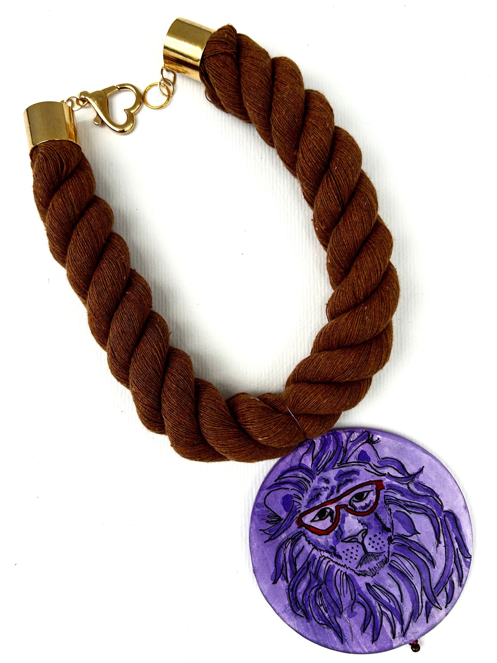 Un collar de cuerda marrón con un colgante de león morado.