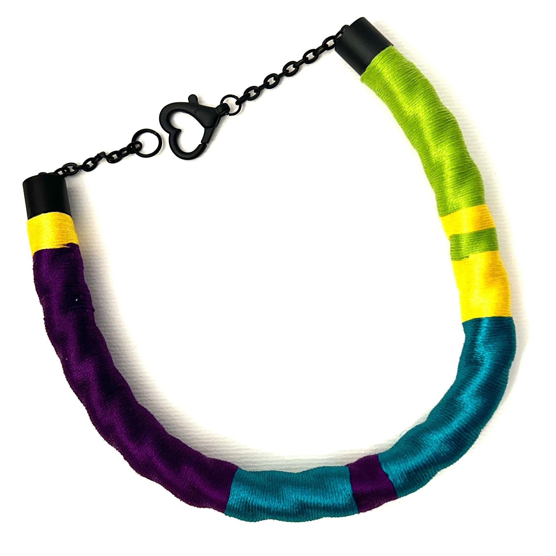 Un collar morado, verde, amarillo y azul con un cierre negro.