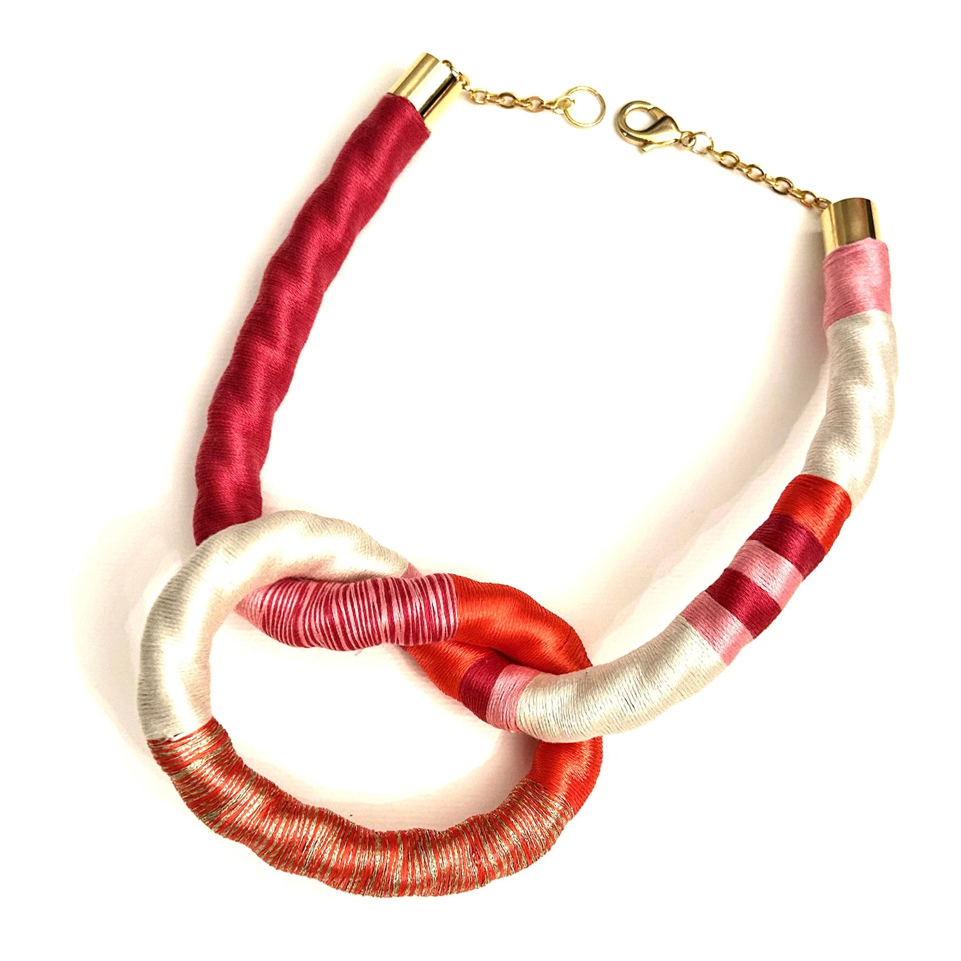 Un collar rosa y blanco con un cierre dorado.